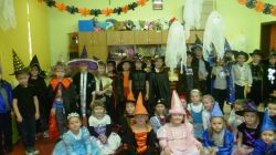 Pamiątkowe zdjęcie przedszkolaków z grup "Sówek" i "Żabek" w strojach wróżek, wróżbitów, czarodziejek, czarodziejów, cyganek i cyganów